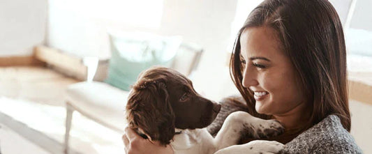 femme tenant un chiot dans ses bras
